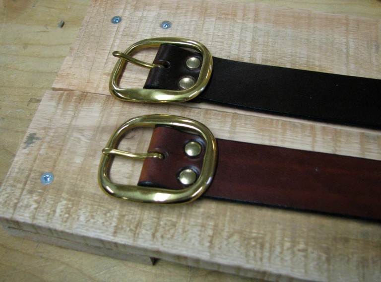 Solid leather belts with buckles secured by rivets
