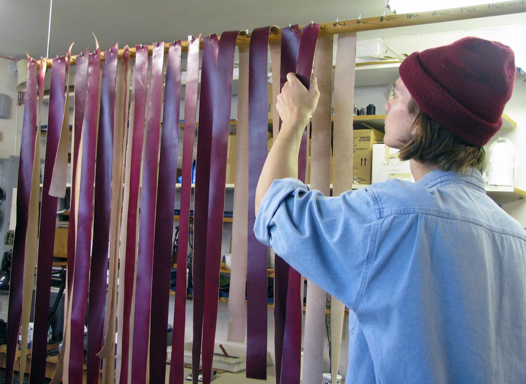 hangs leather straps to dry