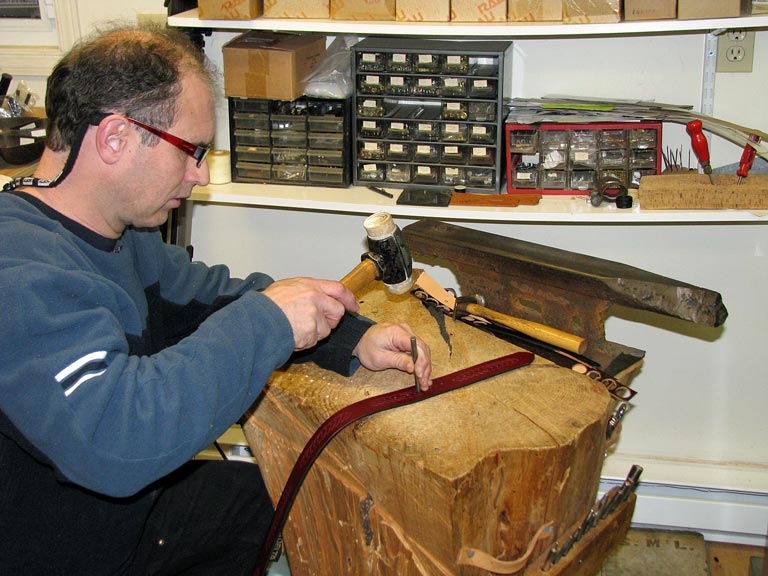 A leather hole punch hand tool used on a leather belt.