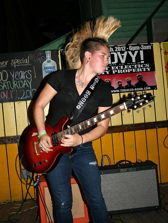 Katie Rocks performs with an etched guitar strap