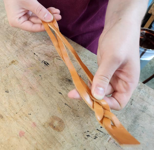 Handcrafting the leather braided bracelet.