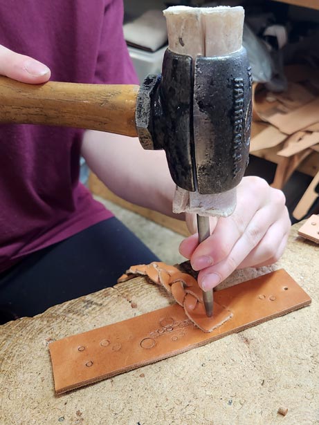 A drive punch tool makes a hole in the leather for the snap.