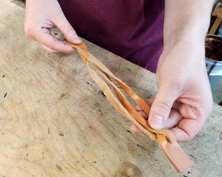 Continuing the weave in the leather magic braided bracelet.